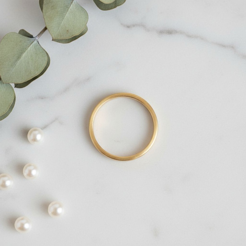 Final result: AI-generated flat lay view of gold ring at 70-degree camera angle